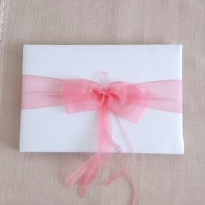 Beautiful wedding guest book. New in box. Measures 10 by 6.5 inches. Coral pink